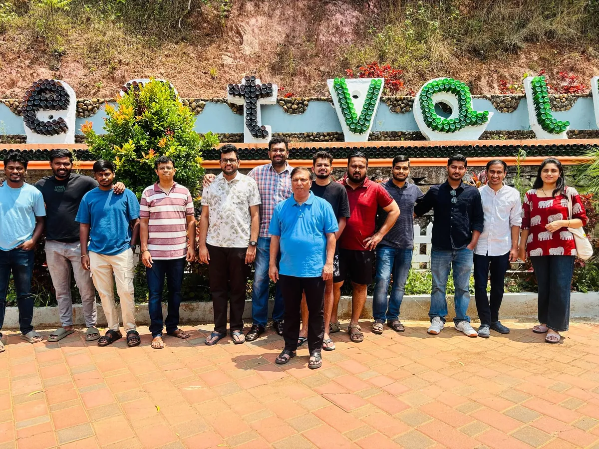 The team posing by a garden sign on an offsite